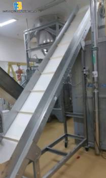Inclined conveyor belt with stainless steel cleats.