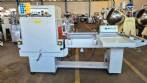 L-shaped packaging sealer with semi-automatic shrink tunnel.